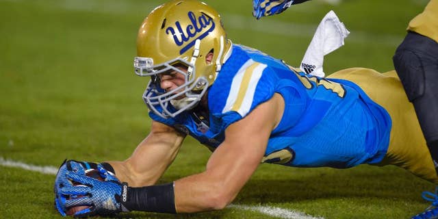 UCLA fullback Taylor Lagace recovers a punt that was fumbled by Southern California's Nelson Agholor during the first half of an NCAA college football game, Saturday, Nov. 22, 2014, in Pasadena, Calif. (AP Photo/Mark J. Terrill)
