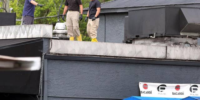 FBI lab personnel walk on the roof of the Pulse Nightclub in June.