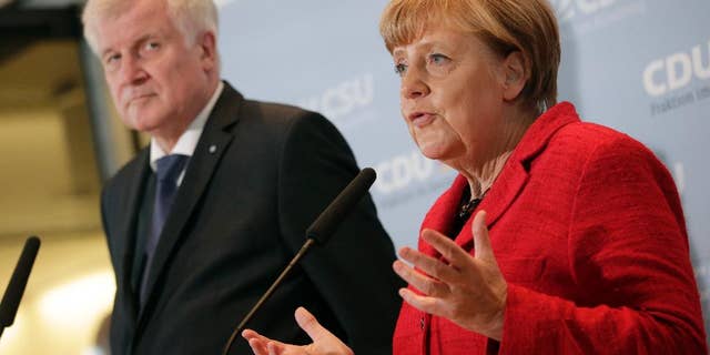 German Chancellor Angela Merkel, right, and the Governor of the German State of Bavaria, Horst Seehofer, left, address the media about the migrant influx.
