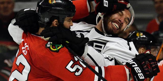 Chicago Blackhawks left wing Brandon Bollig (52) and Los Angeles Kings left wing Dwight King (74) fight during the first period in Game 7 of the Western Conference finals in the NHL hockey Stanley Cup playoffs Sunday, June 1, 2014, in Chicago. (AP Photo/Nam Y. Huh)