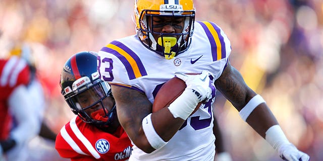 FILE - In this Nov. 17, 2012, file photo, LSU running back Jeremy Hill (33) rushes past Mississippi defensive back Trae Elston (7) on a 27-yard touchdown carry during the first half of their NCAA college football game in Baton Rouge, Hill, already serving two years' probation in connection with a 2011 arrest, was arrested again early Saturday morning, April 27, 2013, after allegedly punching another man in the side of the head outside a Baton Rouge bar near campus. (AP Photo/Gerald Herbert)