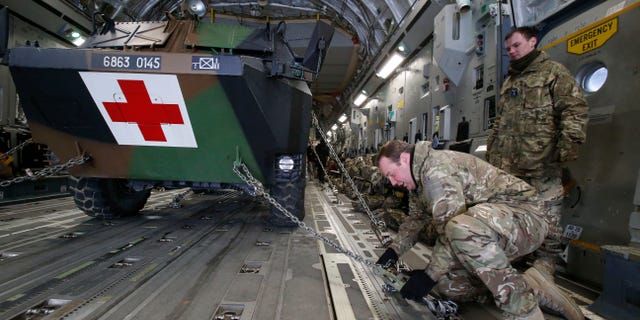A British military personnel fix a French army medical armoured personnel carrier inside a British C17 transport plane prior to take off at army base in Evreux, 90 kms (56 mls) north of Paris, Monday, Jan. 14, 2013. British military equipment was readied for deployment in Mali on Monday as international intervention in the country increased following advances in the north by Islamic extremists with reported links to Al-Qaida. Two C-17 transport planes have arrived at the French military airbase at Evreux, bound for Mali. Two C-17 transport planes have arrived at the French military airbase at Evreux, bound for Mali. (AP Photo/Michel Euler)