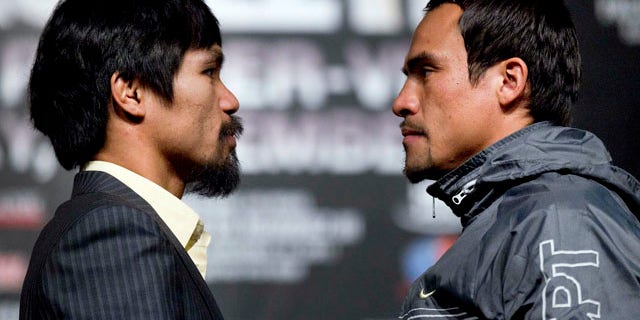 Manny Pacquiao, left, poses for photos with Juan Manuel Marquez during a news conference, Wednesday, Nov. 9, 2011, in Las Vegas. Pacquiao and Marquez will battle for the WBO welterweight championship on Saturday. (AP Photo/Julie Jacobson)