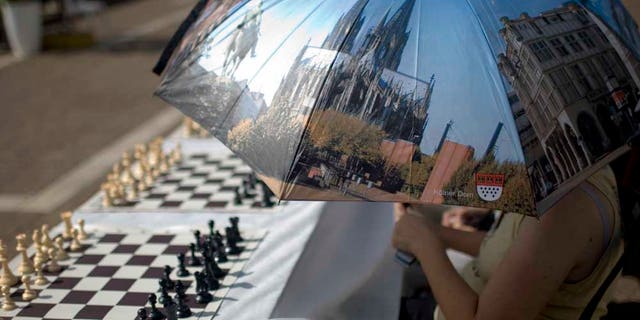 Oct. 21, 2010: A chess player holds a reflective parasol to protect herself from the sun as she waits to play against Israeli chess Grandmaster Alik Gershon, not pictured, during an attempt to break the Guinness world record of simultaneous chess play in Rabin square in Tel Aviv, Israel.