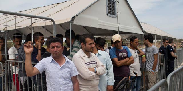 Migrants who live in the Hellenikon refugee and migrant camp of Athens wait to register for asylum on Monday, June 13, 2016. Authorities began registering applications at the site Monday, in a processes expected to last months as more than 50,000 migrants and refugees have been stranded in Greece in the wake of European border closures. (AP Photo/Petros Giannakouris)