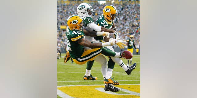 Green Bay Packers' Sam Shields (37) and Morgan Burnett break up a pass intended for New York Jets' Jeremy Kerley during the second half of an NFL football game Sunday, Sept. 14, 2014, in Green Bay, Wis. (AP Photo/Mike Roemer)