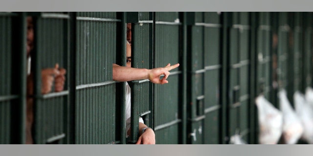 Inmates flash hand signals at the Men's Central Jail in downtown Los Angeles Wednesday, Oct. 3, 2012. Los Angeles County Sheriff Lee Baca says he plans to implement all the reforms suggested by a commission in the wake of allegations that a culture of violence flourished in his jails. (AP Photo/Reed Saxon)