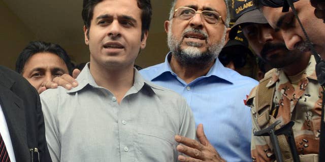 Awais Shah, center left, speaks to journalists with his father Sajjad Ali Shah, center right, chief justice of Sindh's High Court, after the son was rescued from kidnappers.