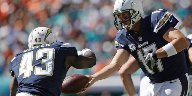 San Diego Chargers quarterback Philip Rivers (17) hands the ball to running back Branden Oliver (43 ) during the first half of an NFL football game against the Miami Dolphins, Sunday, Nov. 2, 2014, in Miami Gardens, Fla. (AP Photo/Alan Diaz)