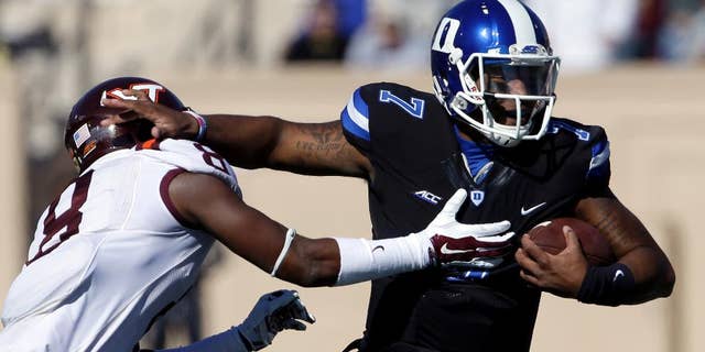 Duke quarterback Anthony Boone (7) runs the ball as Virginia Tech's Detrick Bonner (8) reaches to tackle during the first half of an NCAA college football game in Durham, N.C., Saturday, Nov. 15, 2014. (AP Photo/Gerry Broome)