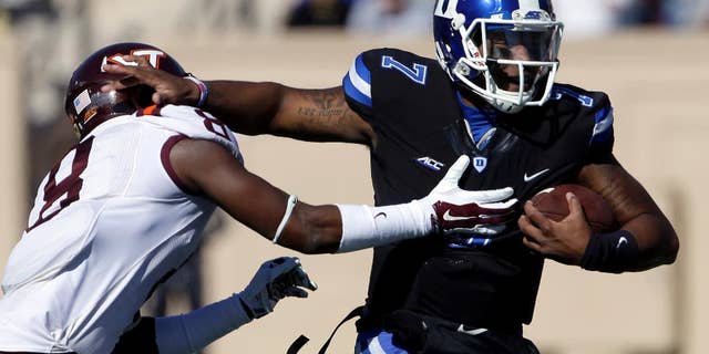 Duke quarterback Anthony Boone (7) runs the ball as Virginia Tech's Detrick Bonner (8) reaches to tackle during the first half of an NCAA college football game in Durham, N.C., Saturday, Nov. 15, 2014. (AP Photo/Gerry Broome)