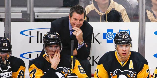FILE - In this Jan. 2, 2016, file photo, Pittsburgh Penguins head coach Mike Sullivan stands behind David Perron (57), and Evgeni Malkin (71) during an NHL hockey game against the New York Islanders in Pittsburgh. The Penguins are on the cusp of a fourth Stanley Cup in large part to coach Sullivan’s uncanny ability to get the attention of a struggling player. (AP Photo/Gene J. Puskar, File)