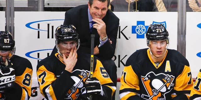 FILE - In this Jan. 2, 2016, file photo, Pittsburgh Penguins head coach Mike Sullivan stands behind David Perron (57), and Evgeni Malkin (71) during an NHL hockey game against the New York Islanders in Pittsburgh. The Penguins are on the cusp of a fourth Stanley Cup in large part to coach Sullivan’s uncanny ability to get the attention of a struggling player. (AP Photo/Gene J. Puskar, File)