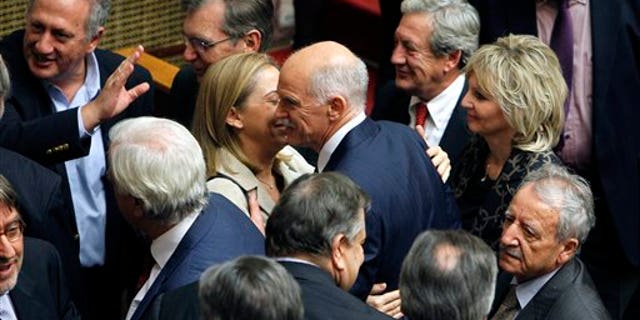 Nov. 5, 2011: Greek Prime Minister George Papandreou, center, is congratulated by his party's ministers and lawmakers after surviving a confidence vote.