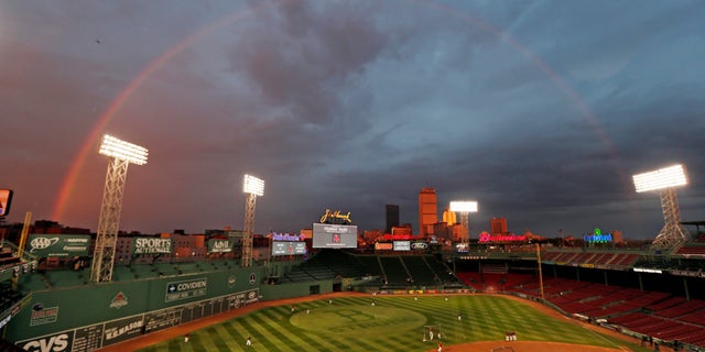 Boston Red Sox players take batting practice as a rainbow appears in the sky above Fenway Park Tuesday, Oct. 22, 2013, in Boston. The Red Sox are scheduled to host the St. Louis Cardinals in Game 1 of baseball's World Series on Wednesday. (AP Photo/Charles Krupa)