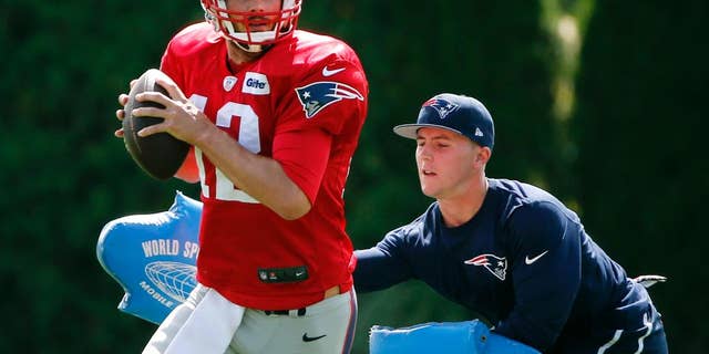 New England Patriots quarterback Tom Brady passes under pressure during a drill at team practice in Foxborough, Mass., Wednesday, Sept. 3, 2014. The Patriots are preparing for their opening NFL football game against the Miami Dolphins on Sunday in Miami. (AP Photo/Elise Amendola)