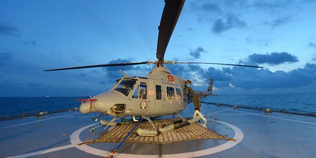 Indonesian navy personnel check a helicopter as they prepare operations to lift the tail of AirAsia Flight 8501 in Java sea, Indonesia Friday, Jan. 9, 2015. Days after sonar detected apparent wreckage, an unmanned underwater vehicle showed the plane's tail, lying upside down and partially buried in the ocean floor. (AP Photo/Adek Berry, Pool)