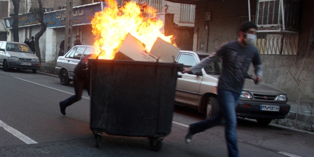 Feb. 14: This photo, taken by an individual not employed by the Associated Press and obtained by the AP outside Iran, shows Iranian protestors moving a garbage can which is set on fire during an anti-government protest in Tehran, Iran.