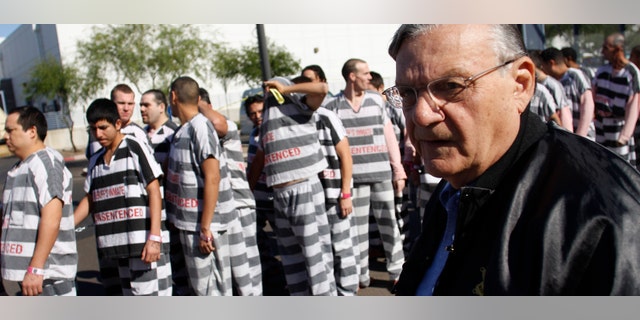 PHOENIX, AZ - APRIL 17: Inmates walk as they are moved after being ordered by Maricopa County Sheriff Officer Joe Arpaio (R), looking on, to be placed into new housing to open up new beds for maximum security inmates on April 17, 2009 in Phoenix, Arizona. Arpaio has been facing criticism from Hispanic activists and lawmakers, alleging that Arpaio's crackdown methods on illegal immigrants involve racial profiling. (Photo by Joshua Lott/Getty Images) *** Local Caption *** Joe Arpaio