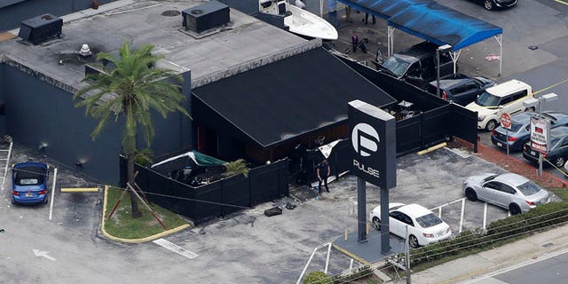 Law enforcement officials work at the Pulse gay nightclub in Orlando, Fla.