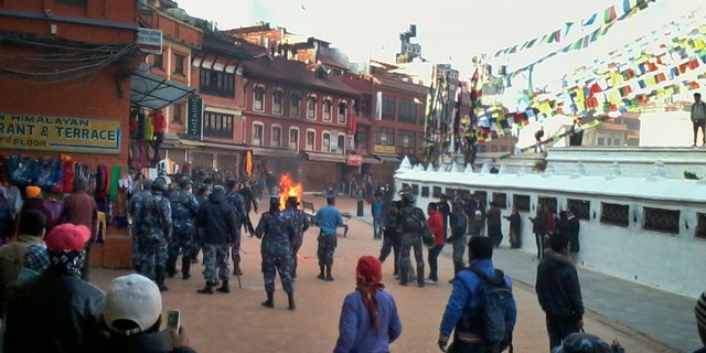 Nepalese policemen rush towards an exiled Tibetan Buddhist monk, center, who self immolated at Boudhanath Stupa in Katmandu, Nepal, Wednesday, Feb. 13, 2013. A police official says the Tibetan man has set himself on fire in Nepal's capital in what is believed to be the latest self-immolation to protest Chinese rule in Tibet. (AP Photo)