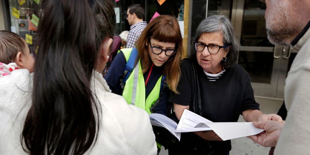 In this Tuesday, April 11, 2017, photo, Sarah Gozalo, center left, and Marisa Lohse, center right, of the New Sanctuary Coalition of NYC, review the Application for Asylum of Joselin Marroquin-Torres, left, before her appearance in federal immigration court in New York.