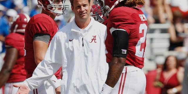 Alabama's offensive coordinator Lane Kiffin, centerr, gestures at running back Derrick Henry (27) before an NCAA college football game against Florida, Saturday, Sept. 20, 2014, in Tuscaloosa, Ala. (AP Photo/Brynn Anderson)