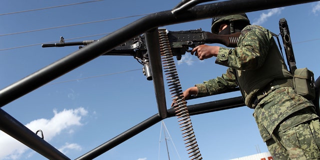 JUAREZ, MEXICO - MARCH 19: A member of the Mexican Army keeps guard near the site of a recent murder on March 19, 2010 in Juarez, Mexico. The border city of Juarez has been racked by violent drug-related crime, making it among the most dangerous cities in the world. As competing drug cartels fight over lucrative drug corridors along the U.S. border, the murder rate in Juarez has risen to 173 slayings for every 100,000 residents. President Felipe Calderon in 2009 disbanded the corrupt local police force and sent 10,000 soldiers to Juarez, but the violence has raged on. With a population of 1.3 million in Juarez, 2,600 died in drug-related violence last year and 500 so far this year, including two Americans who worked for the U.S. Consulate last weekend as they returned from a childrens party. (Photo by Spencer Platt/Getty Images)
