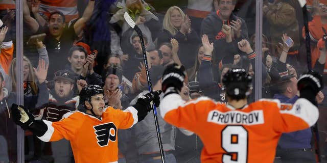 Brayden Schenn van Philadelphia Flyers, links, viert feest met Ivan Provorov nadat Schenn scoorde tijdens de verlenging van een NHL-hockeywedstrijd tegen de Carolina Hurricanes, zondag 19 maart 2017, in Philadelphia.  Filadelfia won met 4-3.  (AP Foto/Matt Slocum)