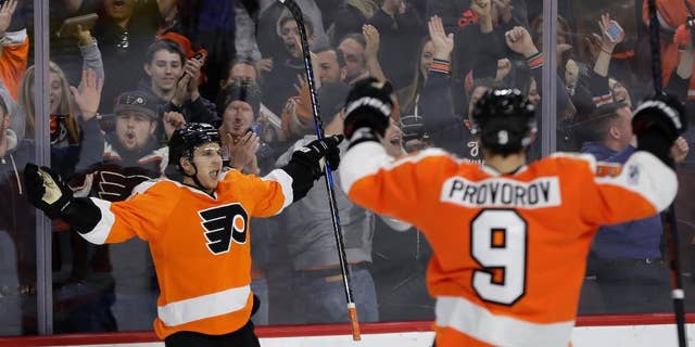 Brayden Schenn van Philadelphia Flyers, links, viert feest met Ivan Provorov nadat Schenn scoorde tijdens de verlenging van een NHL-hockeywedstrijd tegen de Carolina Hurricanes, zondag 19 maart 2017, in Philadelphia. Filadelfia won met 4-3. (AP Foto/Matt Slocum)