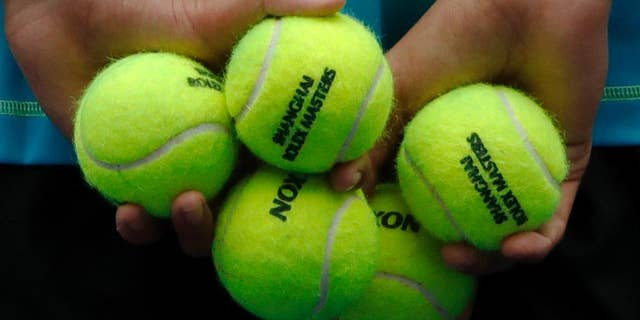 A ball boy holds tennis balls during the men's singles match between Stan Wawrinka of Switzerland and Kyle Edmund of Britain in the Shanghai Masters tennis tournament at Qizhong Forest Sports City Tennis Center in Shanghai, China, Wednesday, Oct. 12, 2016. (AP Photo/Andy Wong)