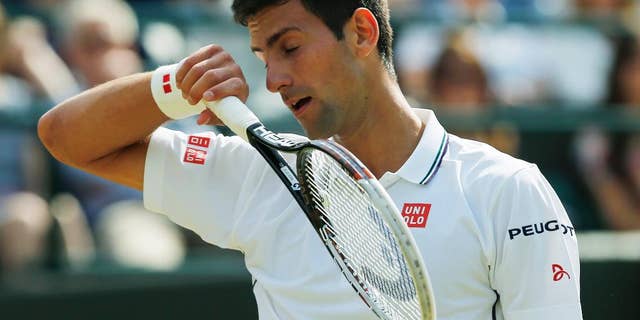 Novak Djokovic of Serbia goes to wipe his face during his men's singles quarterfinal match against Marin Cilic of Croatia at the All England Lawn Tennis Championships in Wimbledon, London, Wednesday, July 2, 2014. (AP Photo/Ben Curtis)