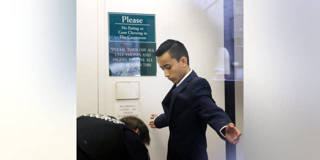FILE- In this April 2, 2014 file photo, Justin Casquejo passes through security at a courthouse in New York. The teenage daredevil who climbed the World Trade Center's centerpiece tower in 2014 has surrendered to police on Friday, Dec. 2, 2016, after videos posted on social media showed him dangling from other Manhattan skyscrapers. (AP Photo/Seth Wenig, File)