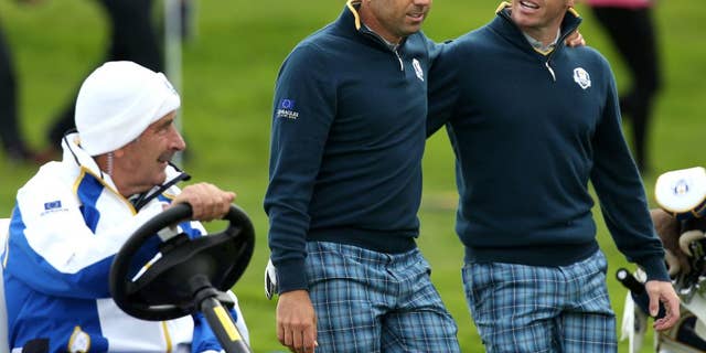 Europe’s Rory McIlroy, right, and Sergio Garcia walk alongside team vice captain Sam Torrance in a golf buggy on the 15th fairway during a practice round ahead of the Ryder Cup golf tournament at Gleneagles, Scotland, Tuesday, Sept. 23, 2014. (AP Photo/Peter Morrison)