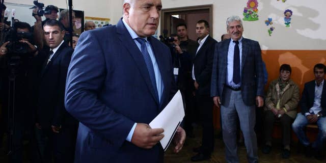 Boyko Borissov, former Bulgarian Prime Minister and leader of centre-right GERB party, holds his voting papers in Sofia, Sunday, Oct. 5, 2014. Opinion surveys predict the biggest vote winner will be center-right GERB party led by a former prime minister, Borisov, who says he would only continue building Bulgaria’s part of the South Stream pipeline if the EU approved. Bulgarians are voting in a parliamentary election hoping a new government will end the political stalemate, revive the economy, solve a severe banking crisis, and find ways to ease Moscow's grip on the country's energy supplies. (AP Photo/STR)