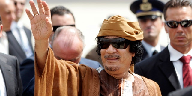 Aug. 29, 2010: Libyan leader Muammar Qaddafi gestures as he arrives at Ciampino airport, near Rome.