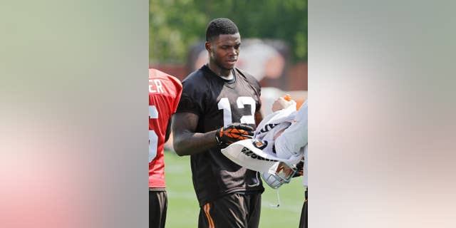 In this Aug. 20, 2014 photo, Cleveland Browns wide receiver Josh Gordon (12) takes a break during practice at the NFL football team's facility in Berea, Ohio. On Wednesday, Aug. 27, 2014, the NFL suspended Gordon for one year for violating the league's substance abuse policy. (AP Photo/Mark Duncan)
