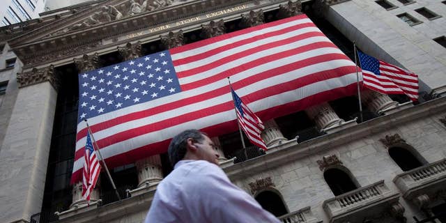 FILE - In this Monday, Aug. 8, 2011 file photo, a pedestrian walks past the New York Stock Exchange in New York. A weak batch of earnings reports is sending the stock market slightly lower in early trading Thursday, April 30, 2015. (AP Photo/Jin Lee, File)