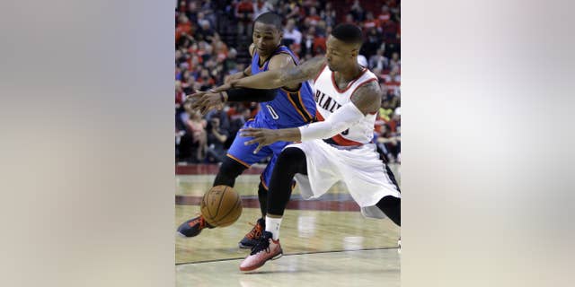 Oklahoma City Thunder guard Russell Westbrook, left, battles for the ball with Portland Trail Blazers guard Damian Lillard during the second half of an NBA basketball game in Portland, Ore., Wednesday, Oct. 29, 2014. Westbrook score 38 points as the Trail Blazers won 106-89.(AP Photo/Don Ryan)