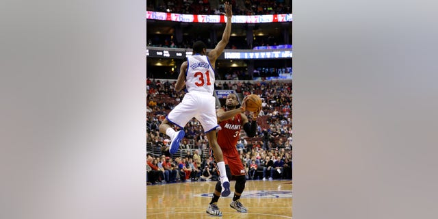 Miami Heat's Dwyane Wade (3) prepares to shoot against Philadelphia 76ers' Hollis Thompson (31) during the first half of an NBA basketball game on Friday, Jan. 17, 2014, in Philadelphia. (AP Photo/Matt Slocum)