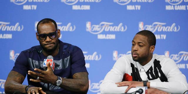 Miami Heat forward LeBron James, left, and Dwyane Wade participate in a news conference after Game 5 of the NBA basketball finals against the San Antonio Spurs, on Sunday, June 15, 2014, in San Antonio. The Spurs won the NBA championship 104-87. (AP Photo/Tony Gutierrez)