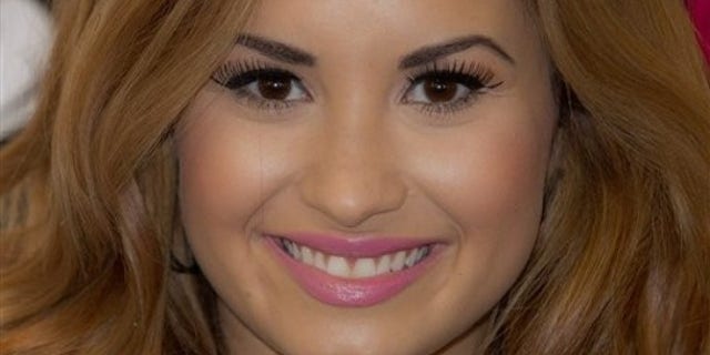 US singer Demi Lovato poses for photographs before she meets fans and signs copies of her new album, 'Unbroken', at a central London music store, Tuesday, April 3, 2012. (AP Photo/Joel Ryan)