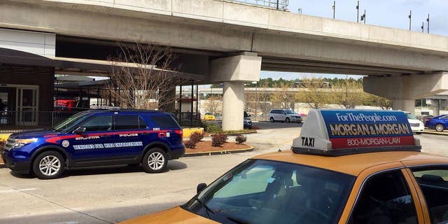 In this March 25, 2016 photo, an Atlanta Police Rides-For-Hire Enforcement vehicle sits amid taxi cabs outside the departures area of the domestic terminal at Hartsfield-Jackson Atlanta International Airport. A battle over background checks for Uber drivers at the world's busiest airport comes as cities like Los Angeles and Austin, Texas, consider more thorough screenings to prevent criminals from getting behind the wheel. Uber has objected to the use of fingerprints to check criminal records of its drivers, saying its own record checks are sufficient. (AP Photo/Jeff Martin)