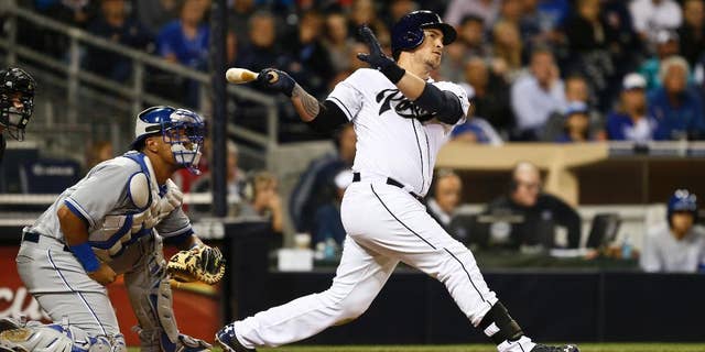 San Diego Padres' Yasmani Grandal and Kansas City Royals catcher Salvador Perez watch as Grandal's 415 foot three run homer heads for the right field seats in the sixth inning of a baseball game Monday, May 5, 2014, in San Diego. (AP Photo/Lenny Ignelzi)