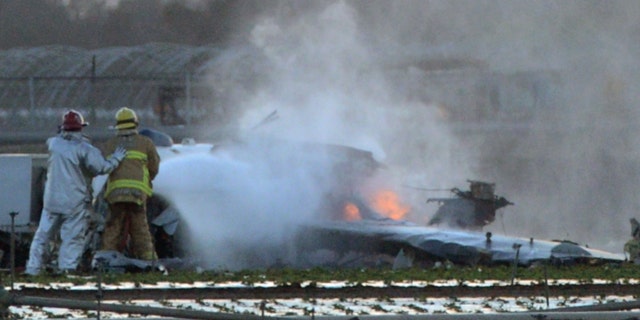 Oct. 29, 2014: Firefighters extinguish the remaining flames of a military airplane that crashed in a field near Naval Station Ventura County near Port Hueneme, Calif., killing the pilot