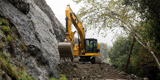 A crew works to clear Santa Rosa Creek Road after a rockslide in Cambria, Callif. Crews worked Wednesday, March 21, 2018, to clean up the rockslide.