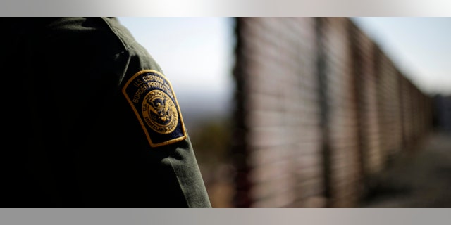 In this June 13, 2013 picture, U.S. Border Patrol agent Jerry Conlin looks to the north near where the border wall ends as is separates Tijuana, Mexico, left, and San Diego, right. Illegal immigration into the United States would decrease by only 25 percent under a far-reaching Senate immigration bill, according to an analysis by the Congressional Budget Office that also finds the measure reduces federal deficits by billions. (AP Photo/Gregory Bull)