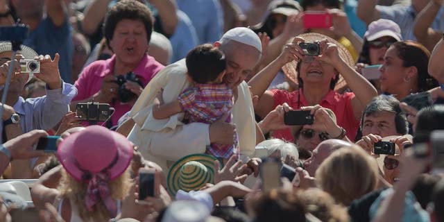 Pope Francis Pope Francis hugs a child as he arrives for his weekly general audience in St. Peter's Square at the Vatican, Wednesday, May 13, 2015. (AP Photo/Alessandra Tarantino)
