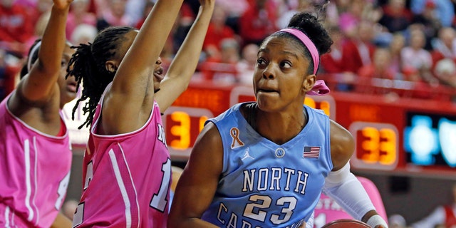 North Carolina's Diamond DeShields (23) is challenged by North Carolina State's Krystal Barrett, center, during the first half of an NCAA college basketball game in Raleigh, N.C., Sunday, Feb. 16, 2014. DeShields had 38 points in North Carolina's 89-82 win. (AP Photo/Karl B DeBlaker)