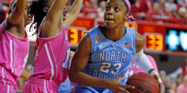 North Carolina's Diamond DeShields (23) is challenged by North Carolina State's Krystal Barrett, center, during the first half of an NCAA college basketball game in Raleigh, N.C., Sunday, Feb. 16, 2014. DeShields had 38 points in North Carolina's 89-82 win. (AP Photo/Karl B DeBlaker)
